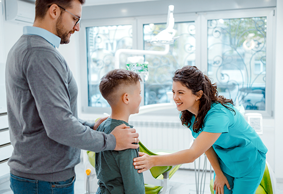 Dentist greeting child and parent
