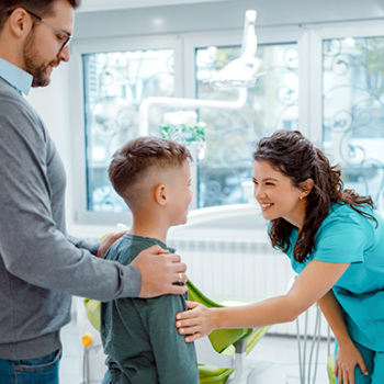 Dentist greeting child and parent