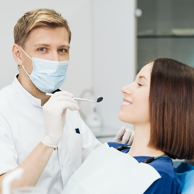 Dentist examining patient with mirror